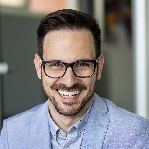 Smiling young business man using digital tablet in the office